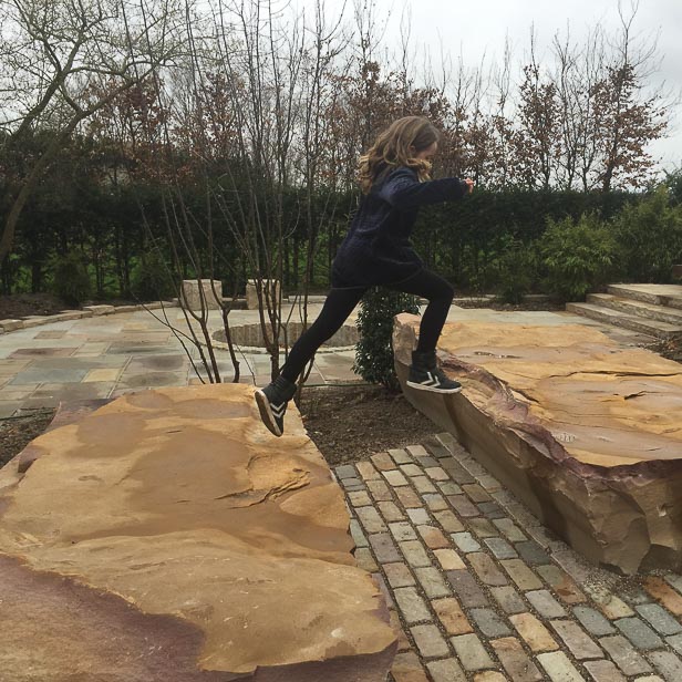 Pige laver parkour på sandstensblokke